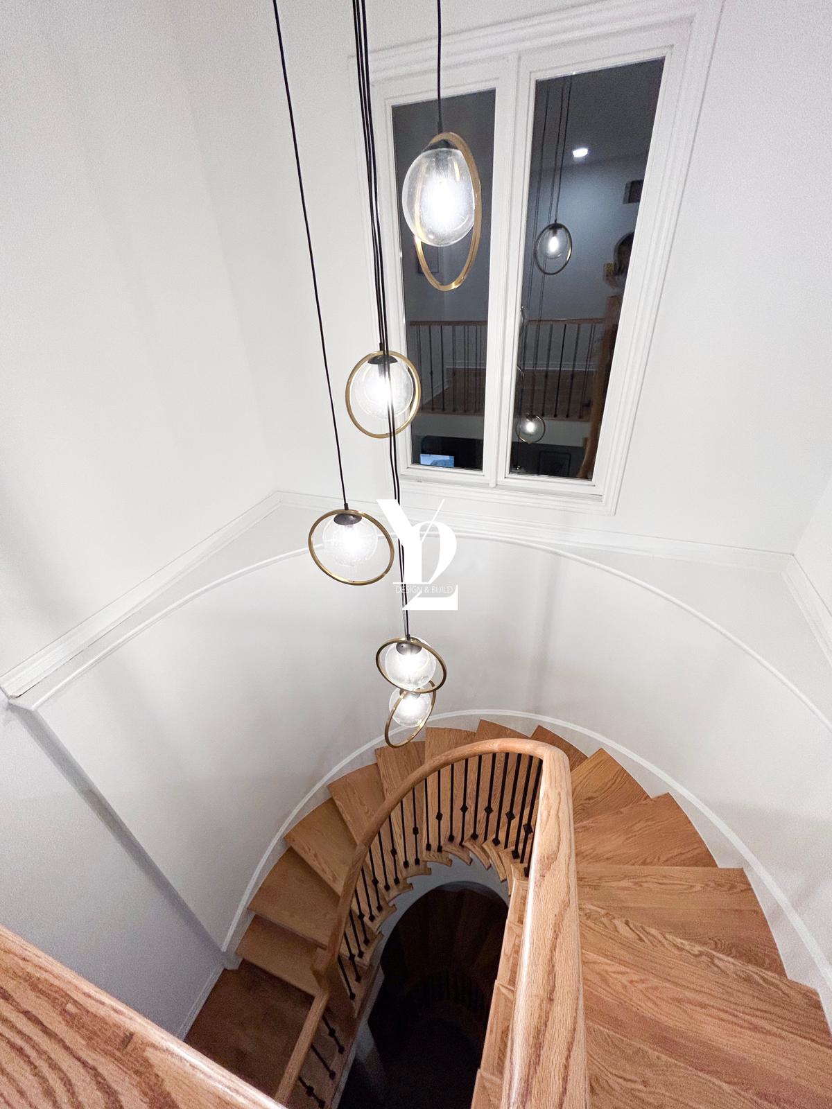 refinished staircase with new pendant lights, stair railing and white paint 